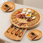 Wooden charcuterie board with assorted foods and cheese knives on a light surface.