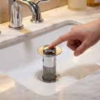 Hand placing a sink drain cover into a bathroom sink.