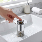 Person adjusting a sink drain cover in a bathroom setting