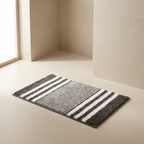 Striped doormat on a light wooden floor with a neutral wall background