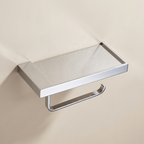 Chrome toilet paper holder with tissue on a beige wall