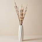White vase with decorative sticks on a beige background