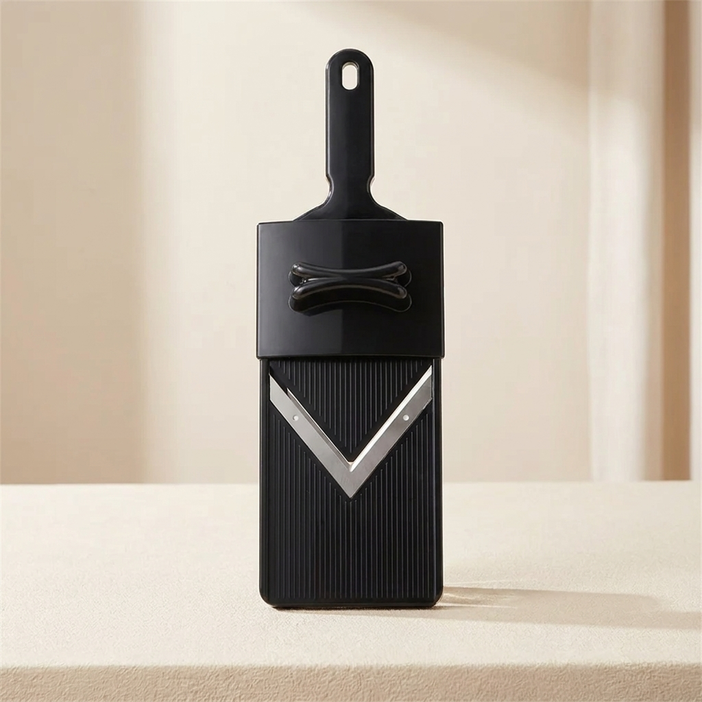 Black and silver kitchen tool on a beige surface with a neutral background