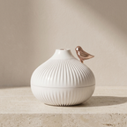 White textured vase with a metallic accent on a beige background