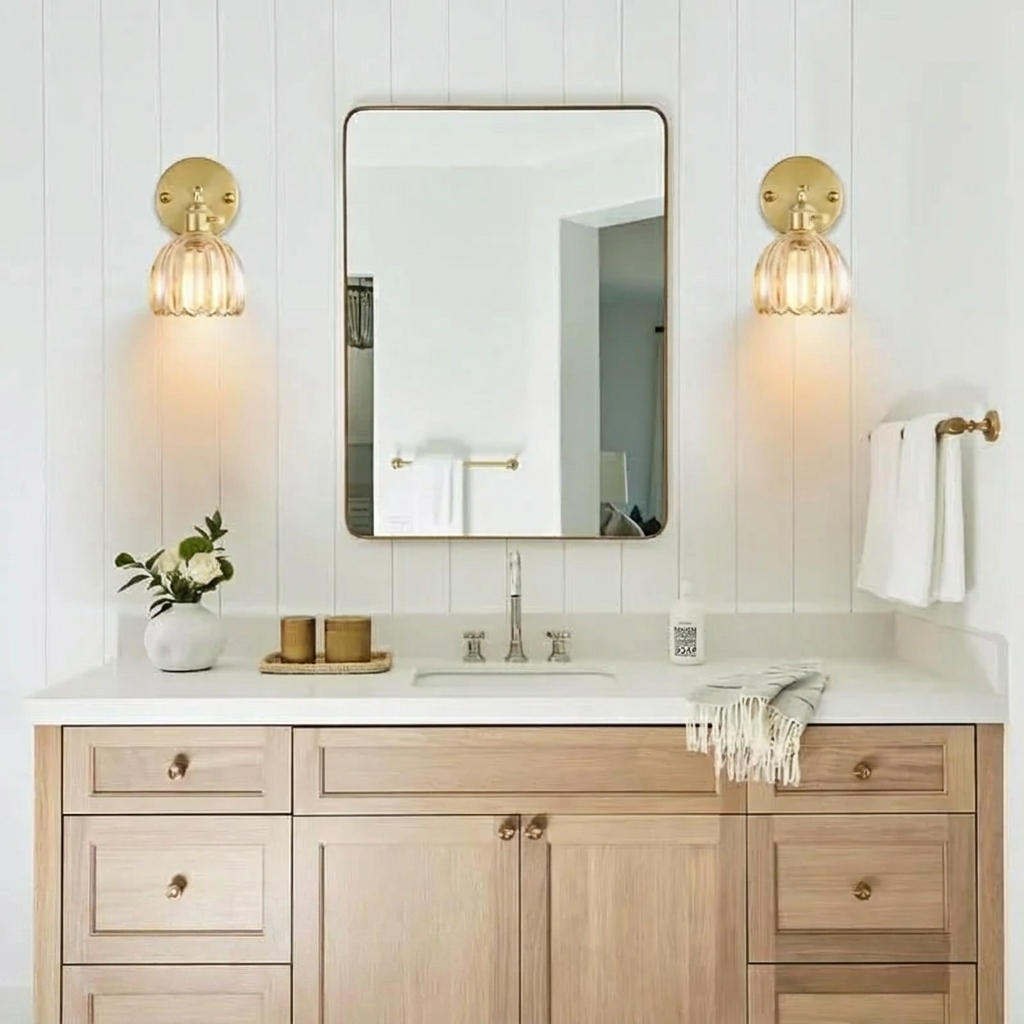 Bathroom vanity with wooden cabinets, mirror, and gold sconces.