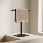 Black towel stand with a beige towel on a neutral background
