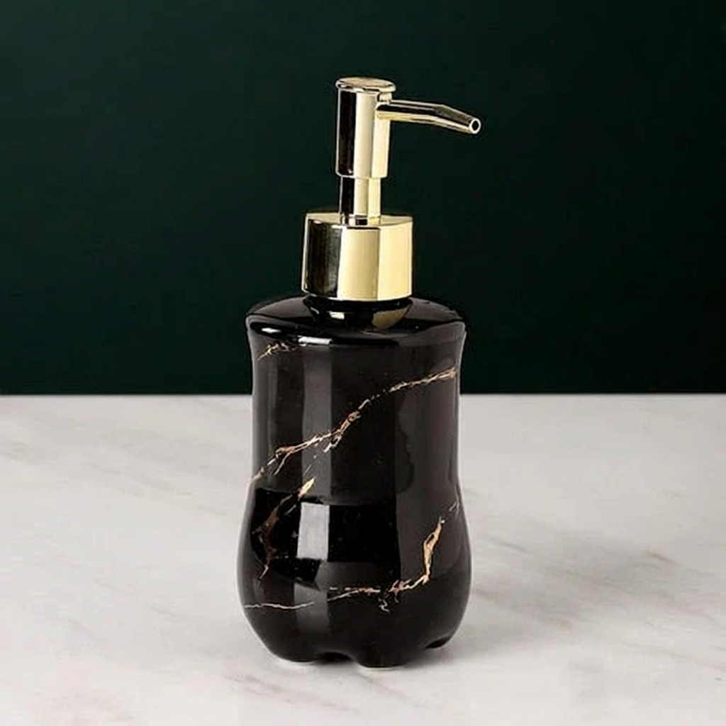 Black marble soap dispenser with gold accents on a white surface and dark background