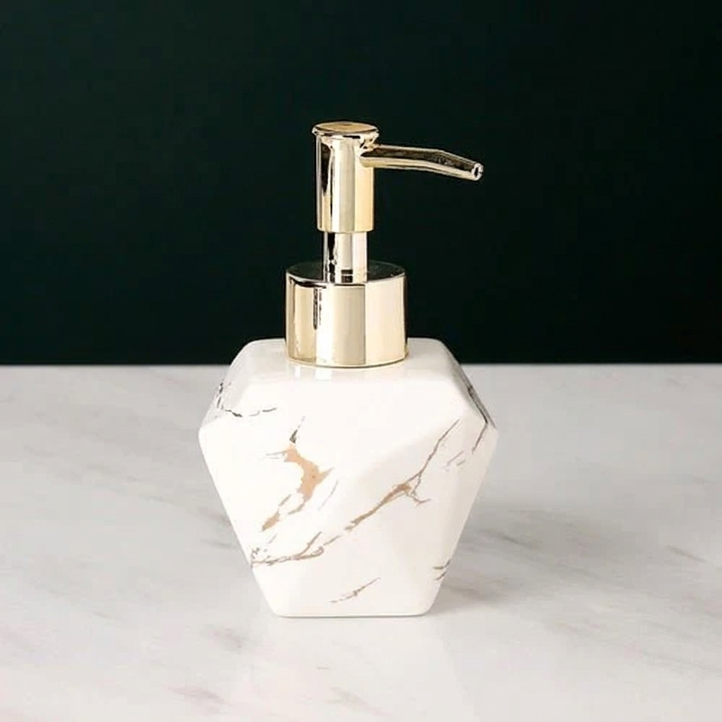 Marble-patterned soap dispenser with gold pump on a white surface