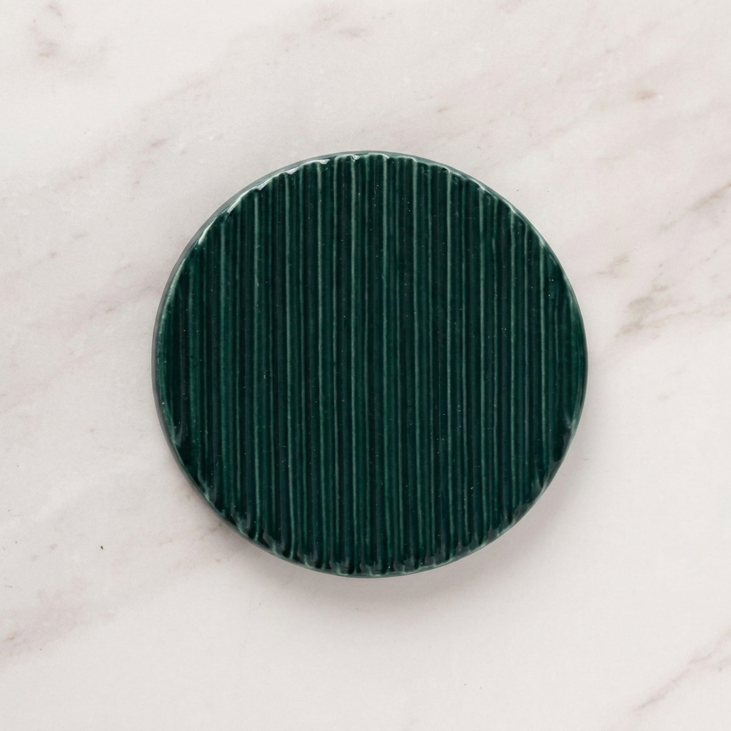Green textured circular object on a light marble background
