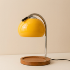 Yellow table lamp with wooden base on a beige background
