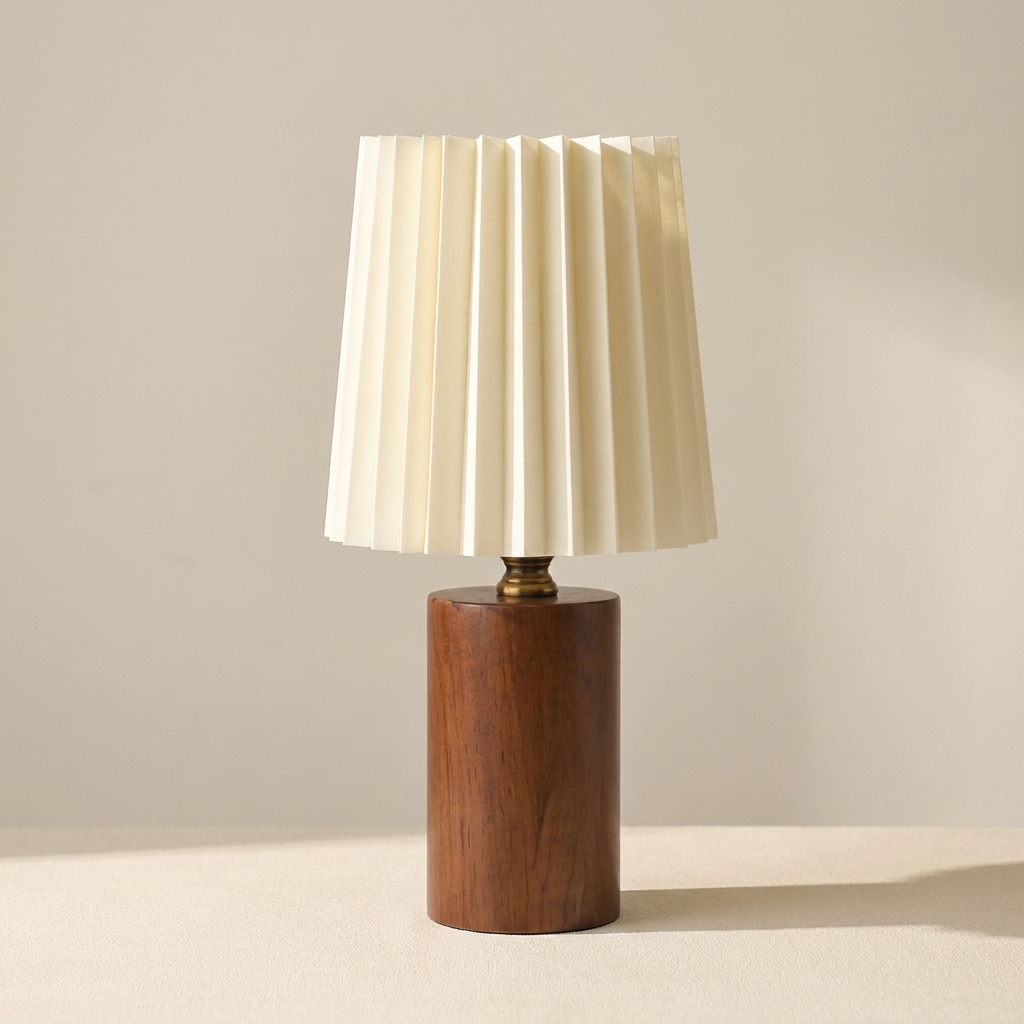 Table lamp with wooden base and white pleated shade on a neutral background
