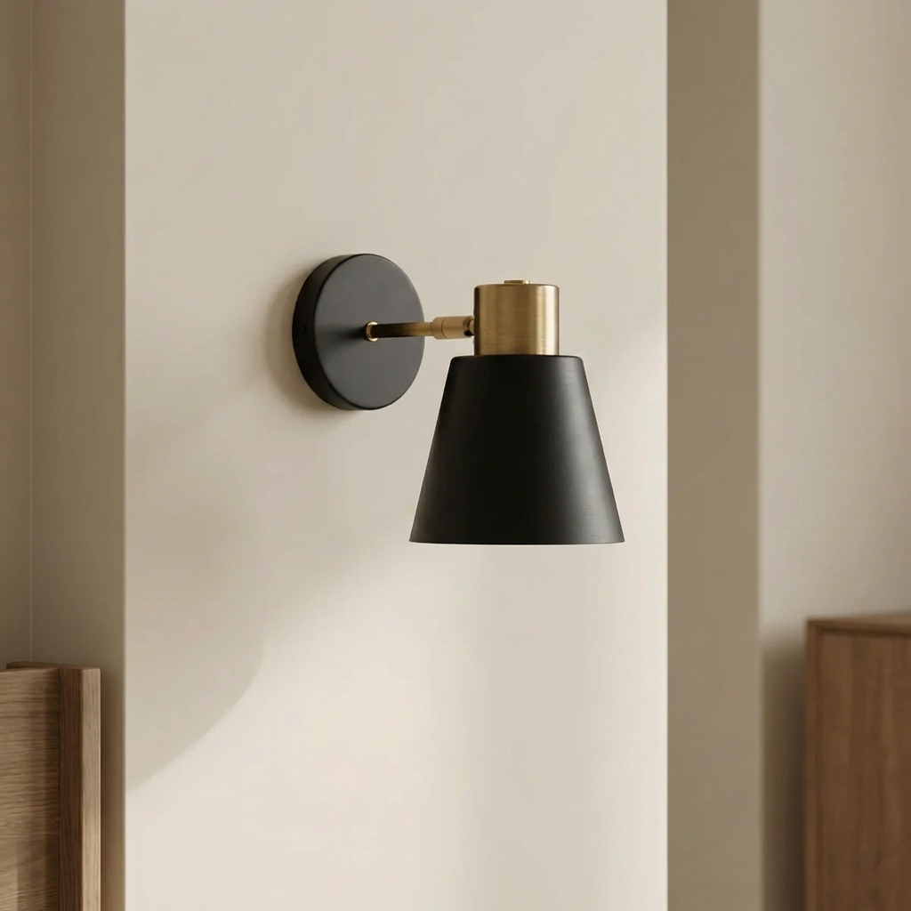 Wall-mounted lamp with black shade and gold fixture on a beige wall.