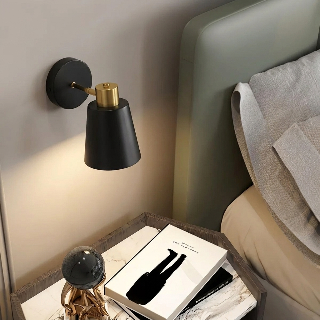 Black wall sconce on a wall next to a bed with a nightstand.