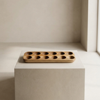 Wooden tray with multiple compartments on a light beige surface.