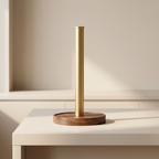 Gold and wooden lamp on a white surface with a neutral background