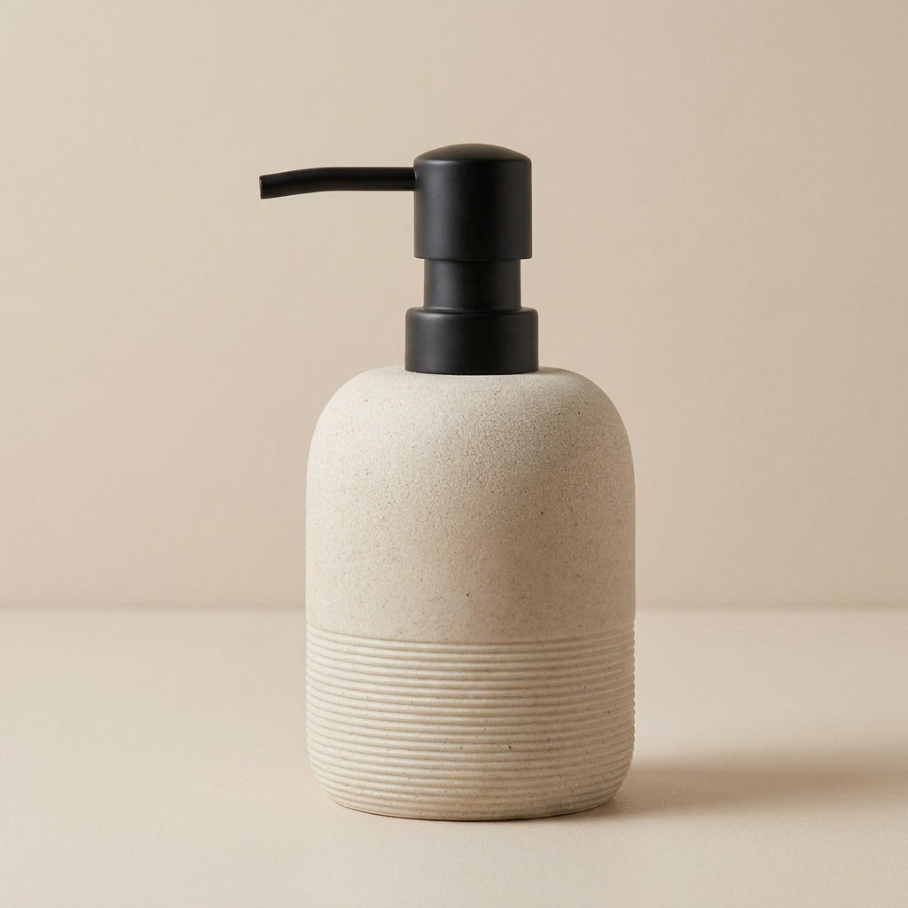 Beige soap dispenser with black pump on a beige background