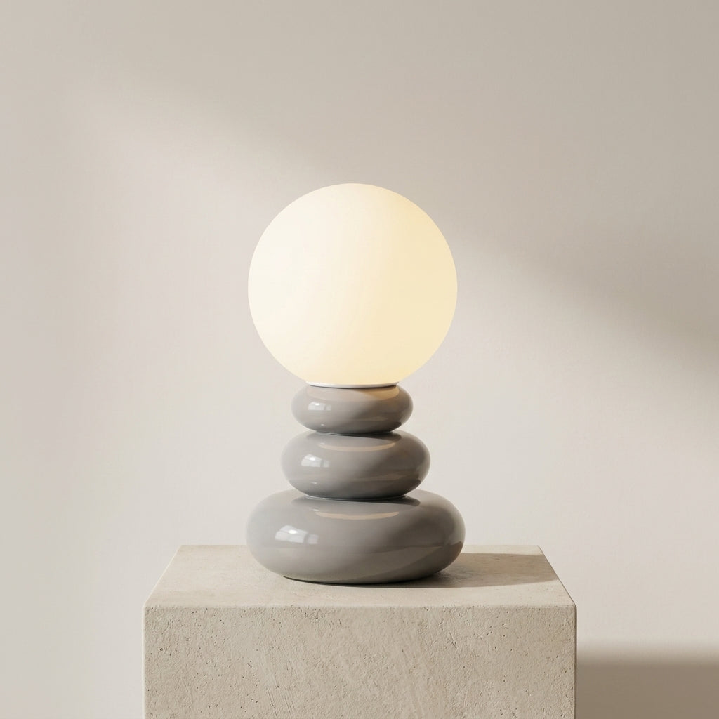 Modern table lamp with a stack of gray ceramic bases on a neutral background