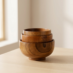 Stack of wooden bowls on a light surface with a neutral background