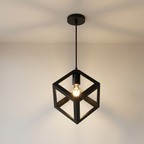 Black cube-shaped pendant light hanging from a ceiling