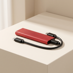 Red external hard drive with USB cable on a beige surface