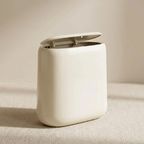 White trash bin with open lid on a beige surface
