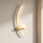 Gold wall sconce on a light gray wall
