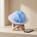 Decorative lamp shaped like a planet on a wooden stand with a remote control on a beige surface.