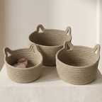 Three woven baskets of different sizes on a light surface with a neutral background