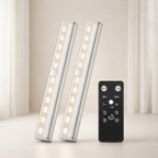 Two cylindrical LED lights with a remote control on a light background