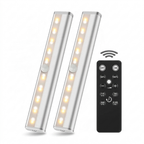 Two cylindrical LED lights with a remote control on a white background