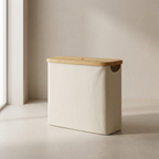 Beige laundry basket with a wooden lid on a neutral background