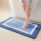 Person stepping onto a blue bath mat with white border
