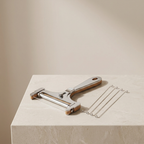 Metal kitchen tool with wooden handle on a light surface