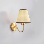 Wall-mounted lamp with a beige shade and gold fixture on a light gray background
