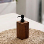 Wooden soap dispenser with black pump on a woven mat