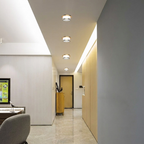 Modern office hallway with ceiling lights and a reception desk.