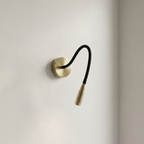 Wall-mounted reading lamp with flexible black arm on a light beige wall