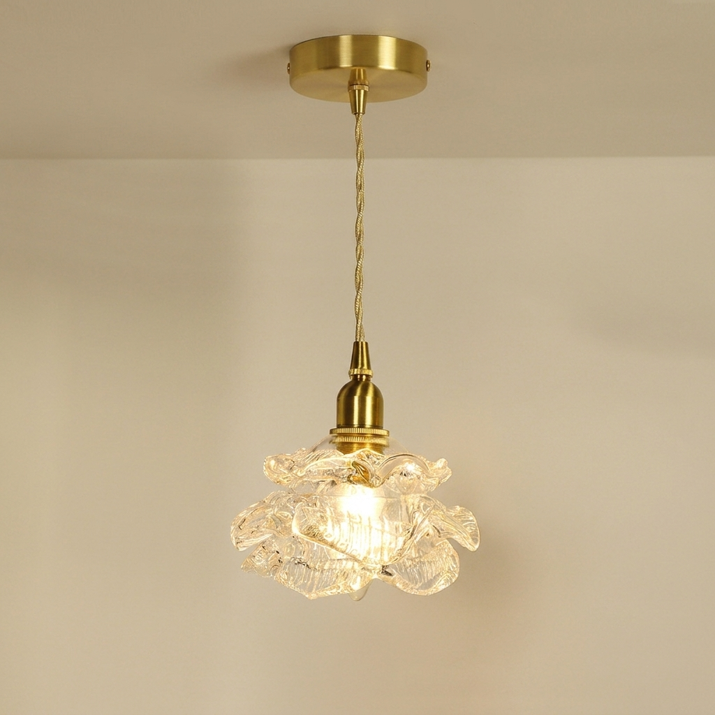 Decorative pendant light with floral glass shade and gold fixture on a beige background
