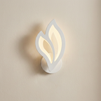 Wall-mounted light fixture with leaf-like design on a beige wall