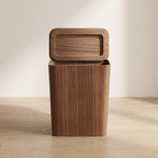 Wooden trash can with lid on a wooden floor