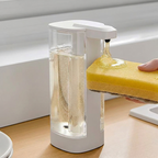 Foam soap dispenser with a sponge on a kitchen counter