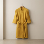 Yellow robe hanging on a hook against a beige wall