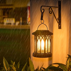 Decorative outdoor lantern on a wall with warm glow in the rain