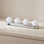 Modern light fixture with four round white lights on a neutral background