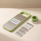 Multifunctional kitchen tool with green handle and silver components on a beige background
