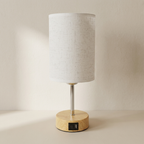 Table lamp with wooden base and white fabric shade on a neutral background