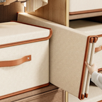Beige storage basket with brown handles on a wooden surface