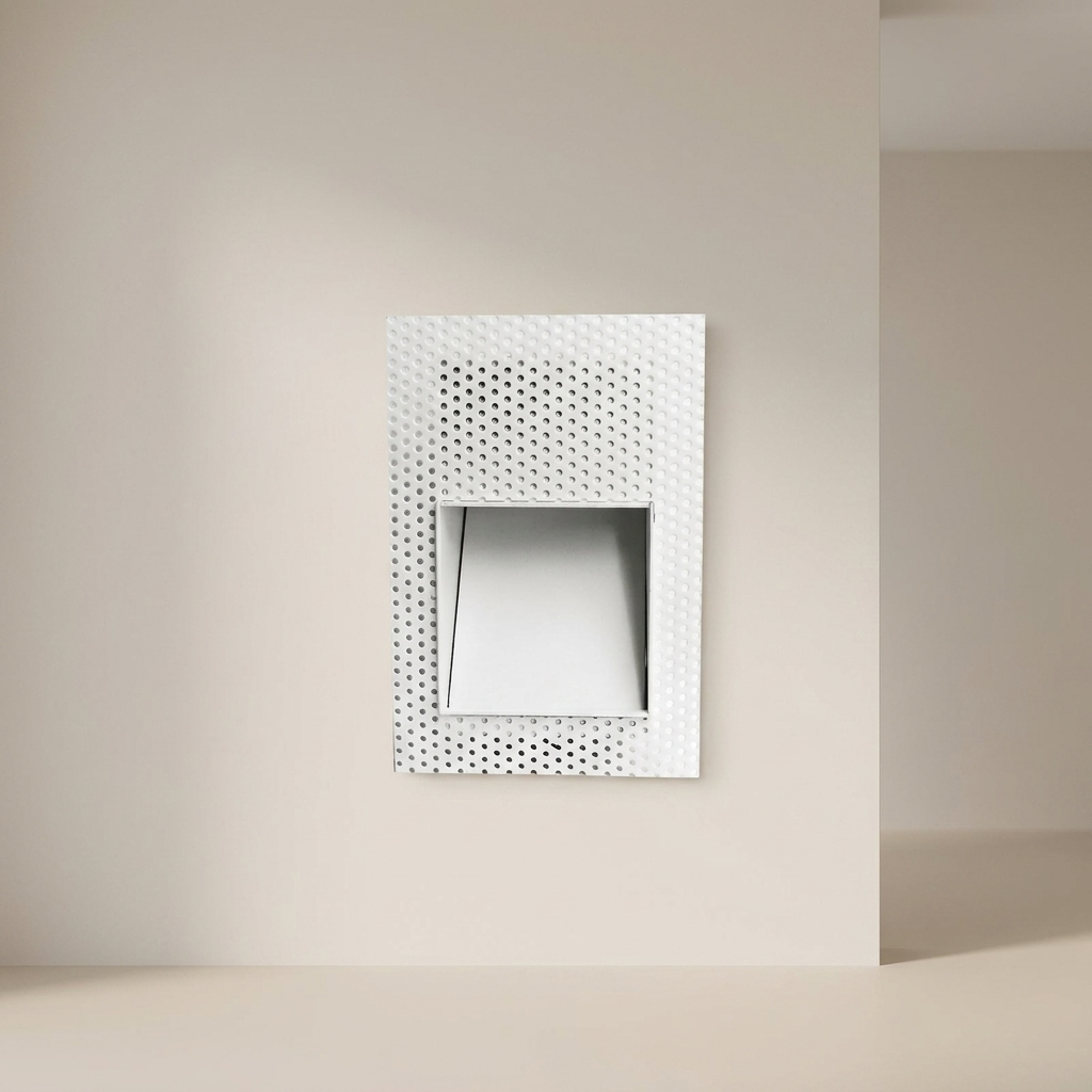 Decorative wall mirror with a geometric pattern on a beige wall.