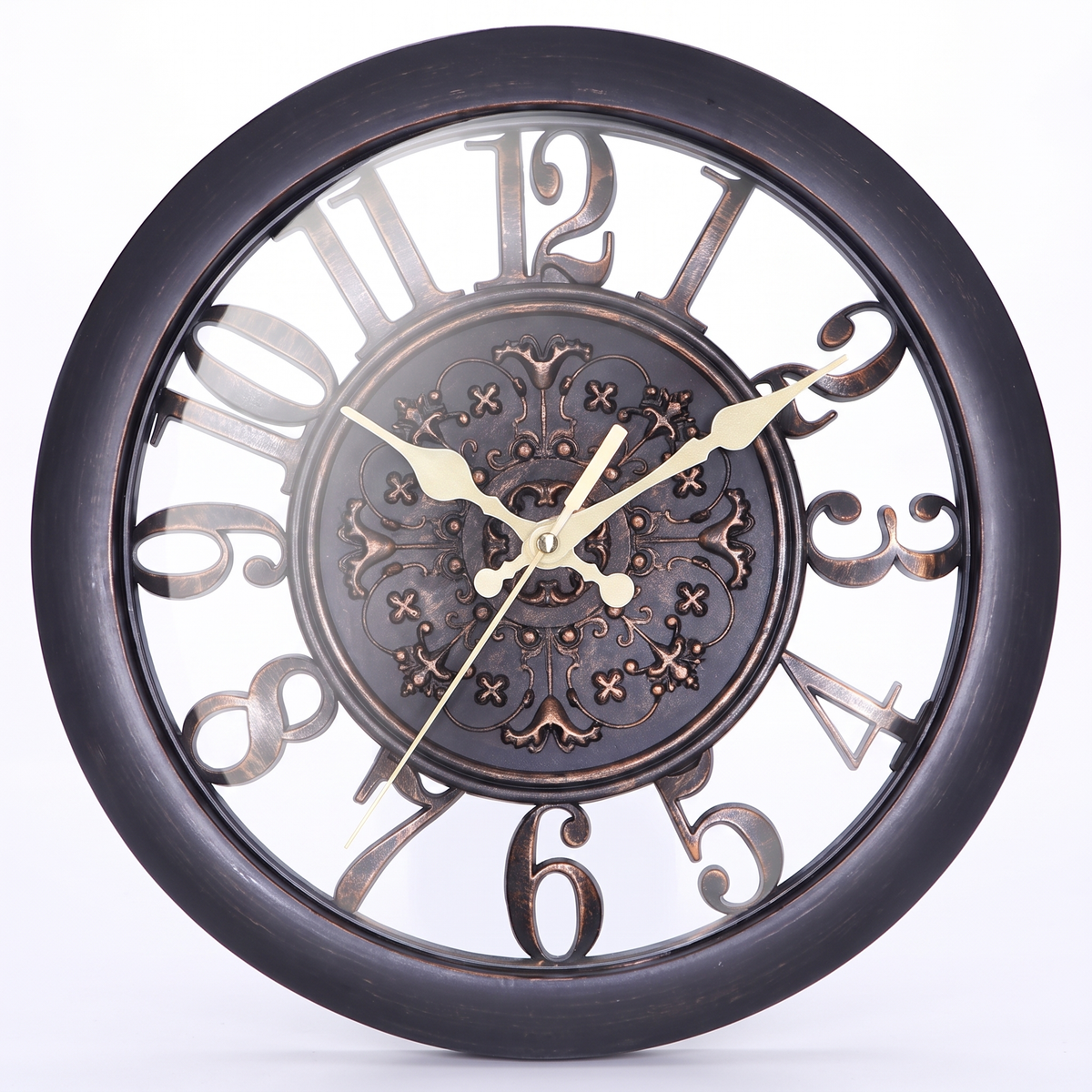 A round wall clock with a dark bronze or black metal frame, featuring large decorative cutout numerals and a detailed ornate center medallion. The clock hands are a warm gold/brass color, and the clock is photographed against a clean white background.