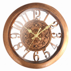 A round wall clock with a warm brown wood-grain frame, a central bronze-toned ornate medallion, and large cutout numerals with gold hands on a white background.